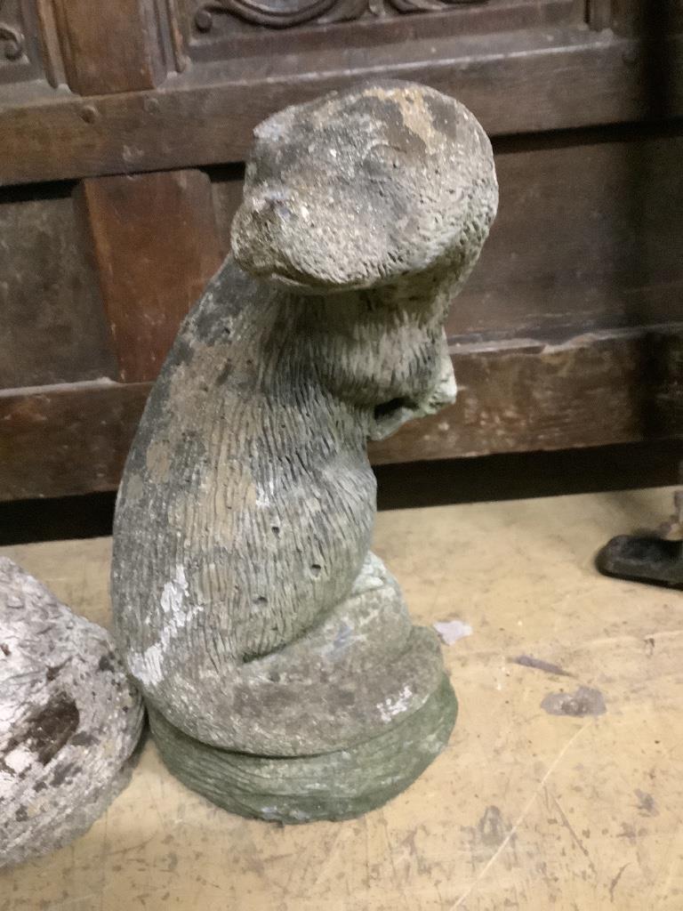 Three reconstituted stone otter garden ornaments, tallest 36cm